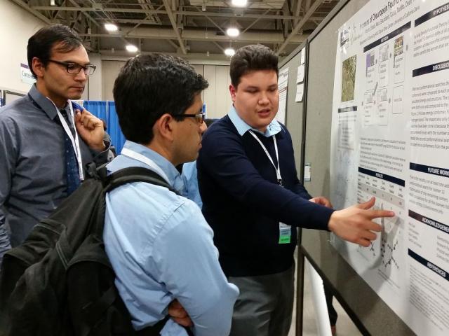 Student giving poster presentation at a conference