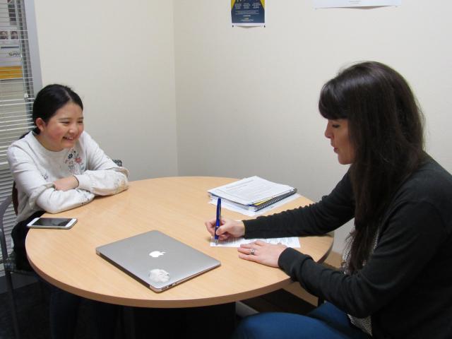 Undergraduate and graduate student seated at table during advising session