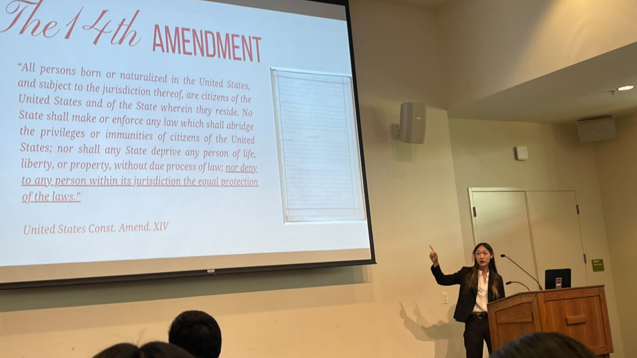 Presenter pointing at 14th Amendment slide in a university lecture hall