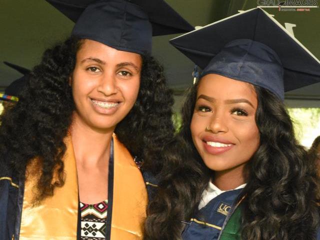 Two graduate students in graduation caps
